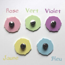 Photo du dos des pins, un de chaque couleur : rose pastel, vert pastel, violet pastel, jaune pâle, bleu clair. Le dos est en acrylique colorées unie avec une accroche sécurisée en métal.